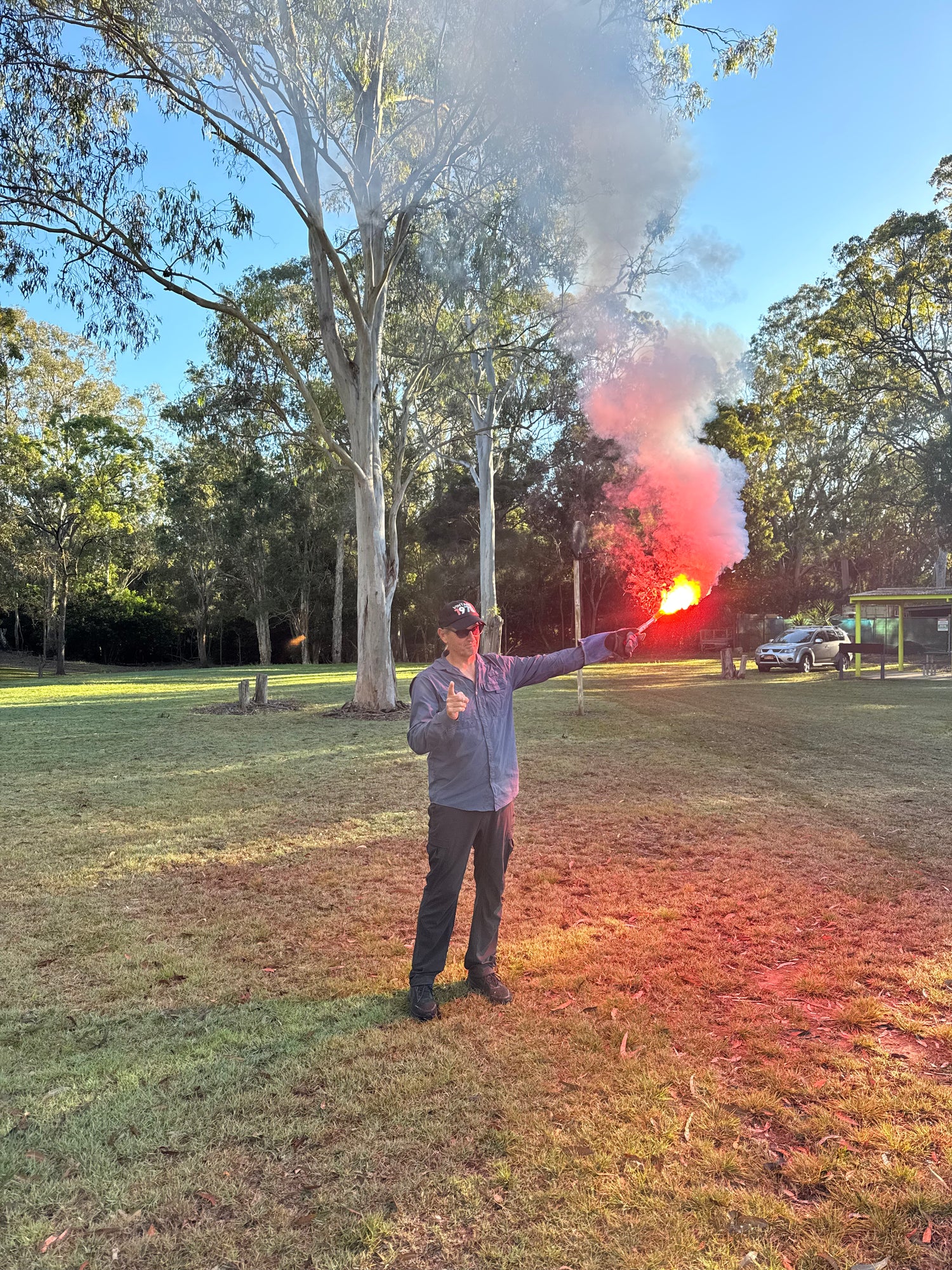 Coxswain student demonstrating a red hand distress flare during emergency procedures training